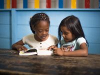 Year of the Bible: Two girls read the Bible together.