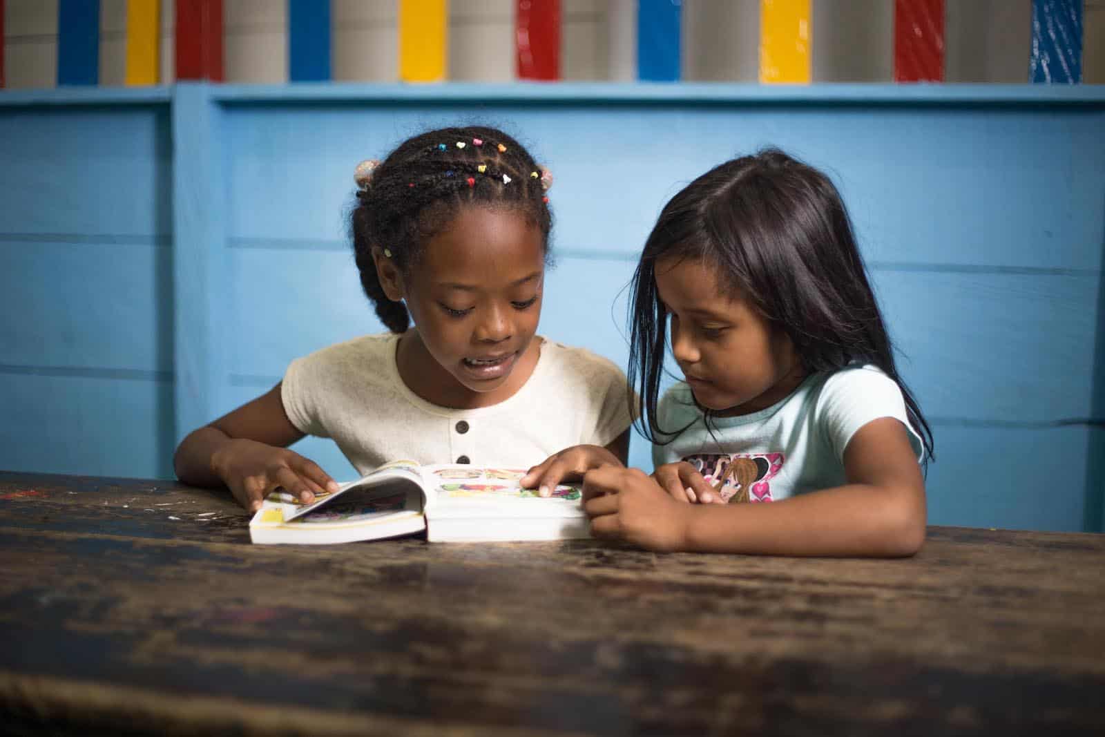 Year of the Bible: Two girls read the Bible together.