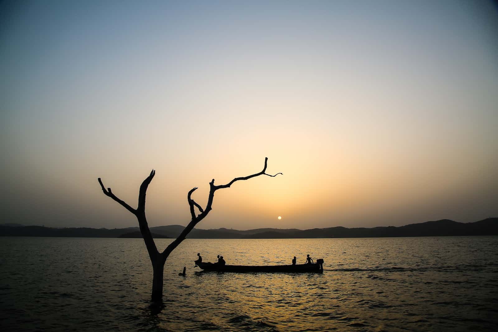 A canoe silhouetted at sunset on a lake.