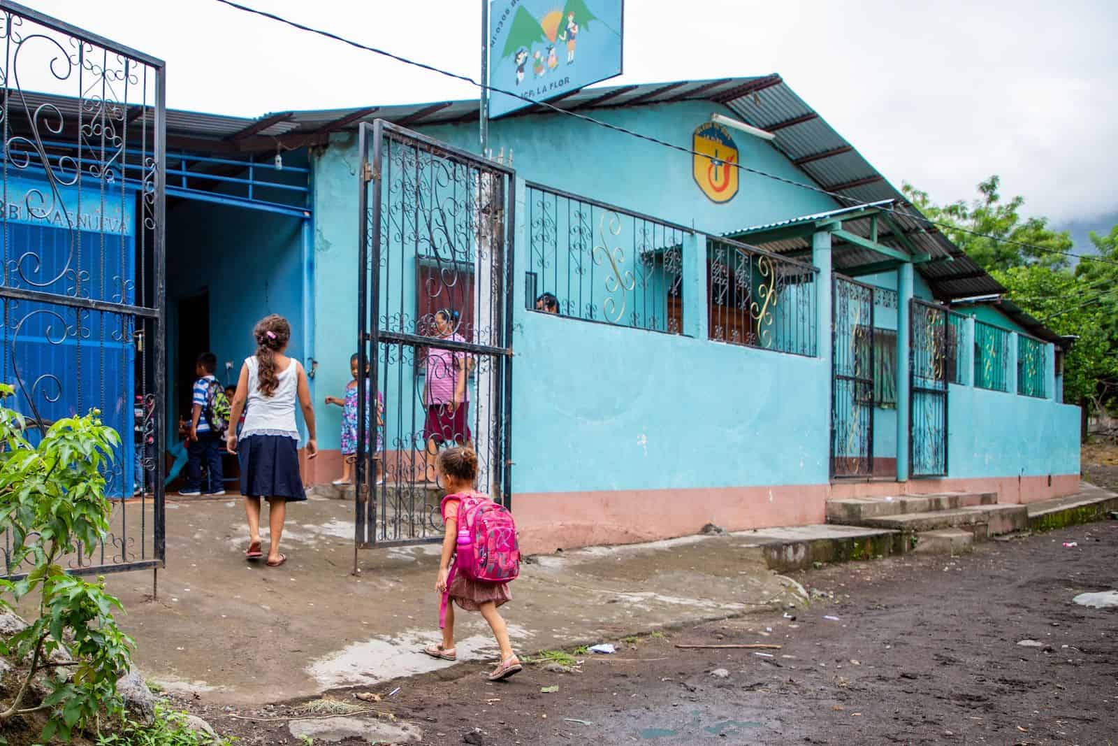 Children walk into a turquoise child development center where people were impacted by Nicaragua unrest. 