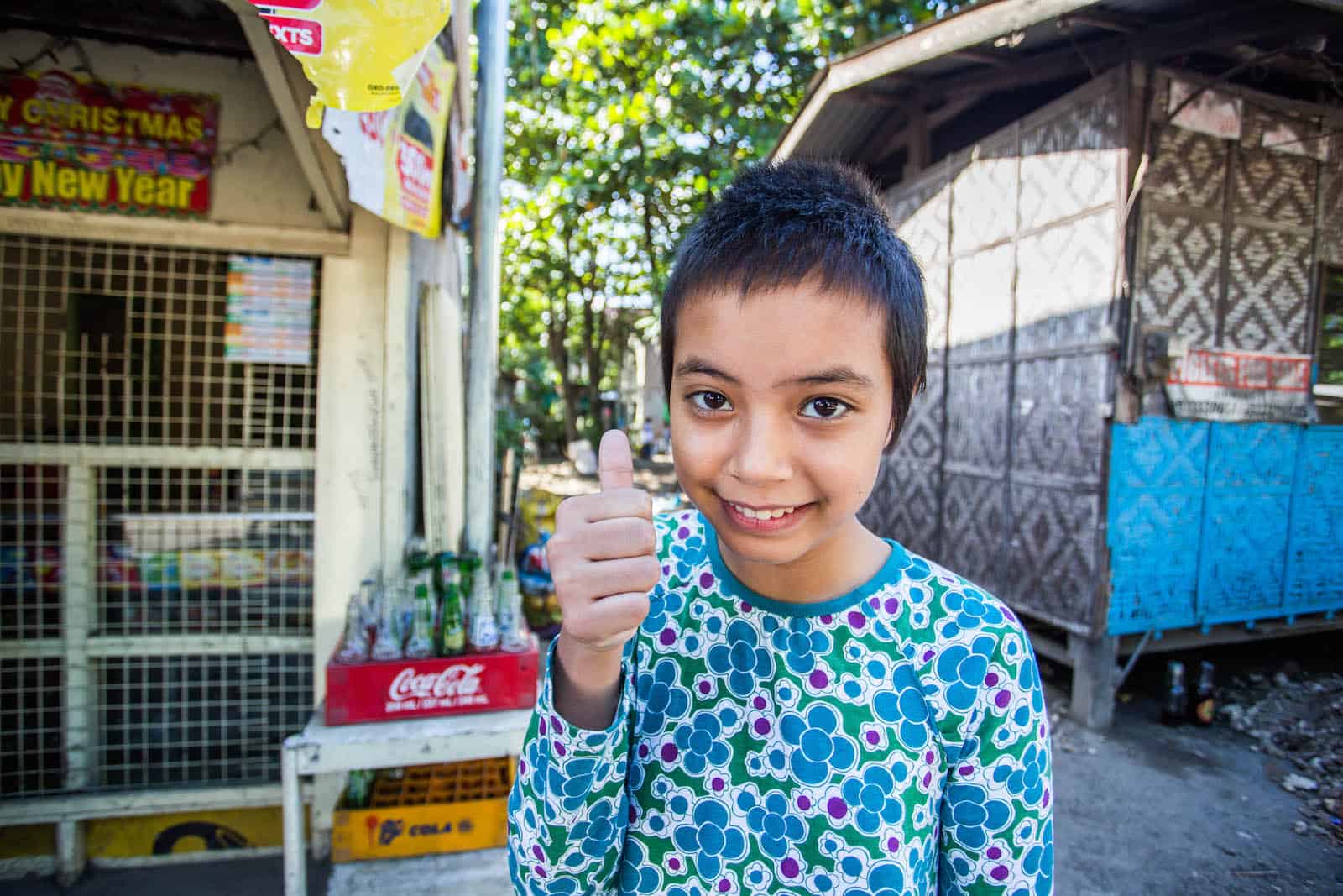 A girl gives the thumbs up sign.