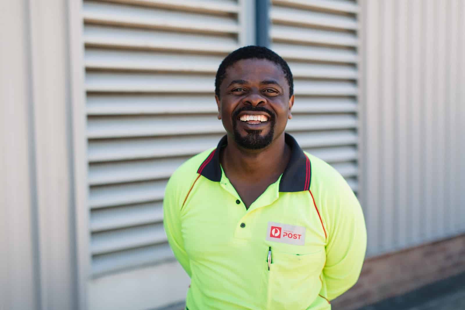 A man in a yellow shirt smiles at the camera.