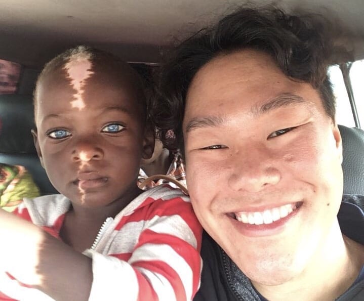 A boy with Waardenburg Syndrome sitting next to a smiling man.