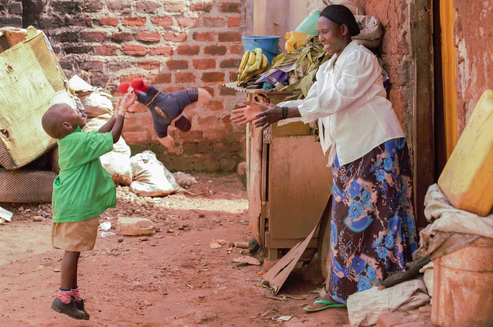 Waardenburg Syndrome Pictures: a boy with partial albinism tosses a toy outside a home to an older woman.