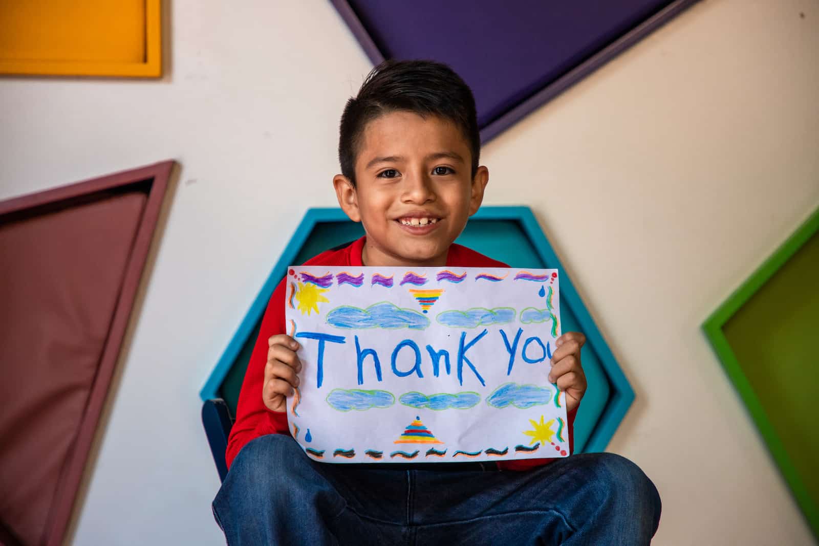 A boy holds a sign that says thank you