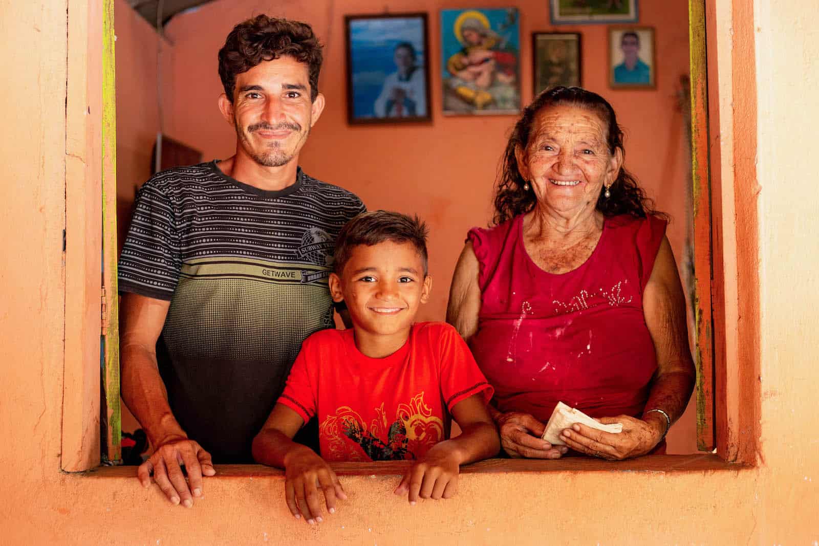 A man, a boy and an elderly woman stand in a door.