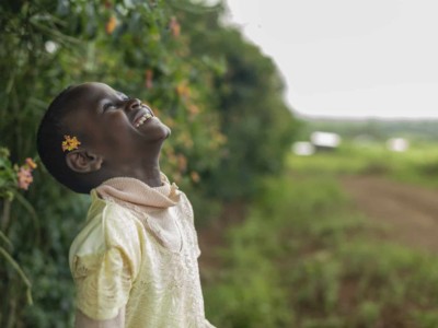 A girl throws her head back and smiles.