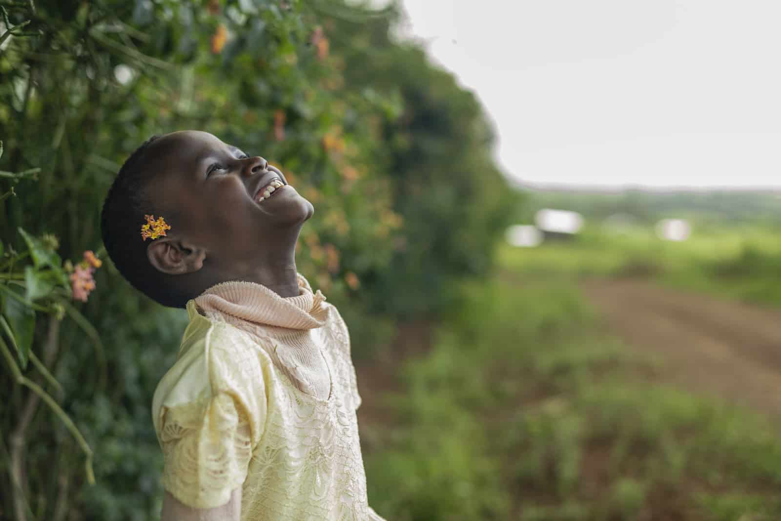 A girl throws her head back and smiles.