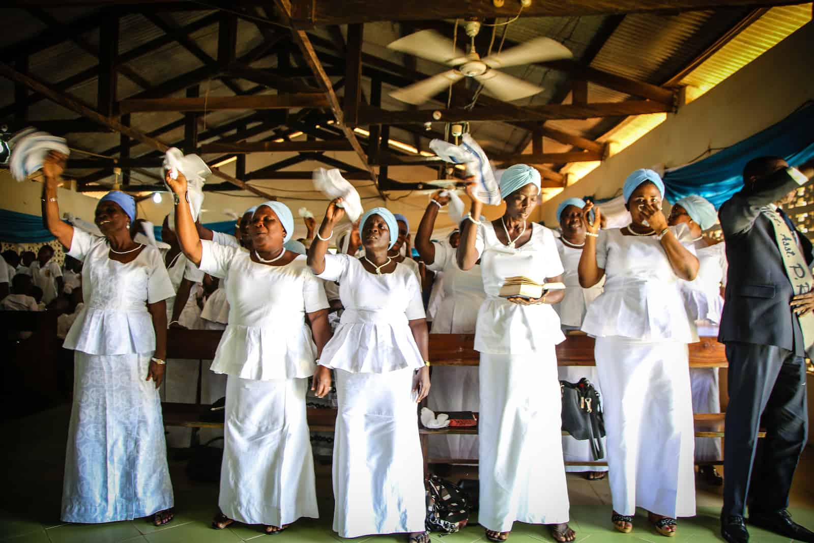 Women sing in a church in Ghana, wearing all white.