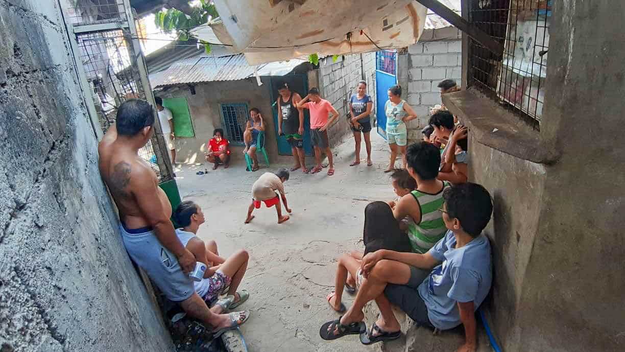 People sit outside their homes in a slum in Cebu City where they are supposed to be social distancing.
