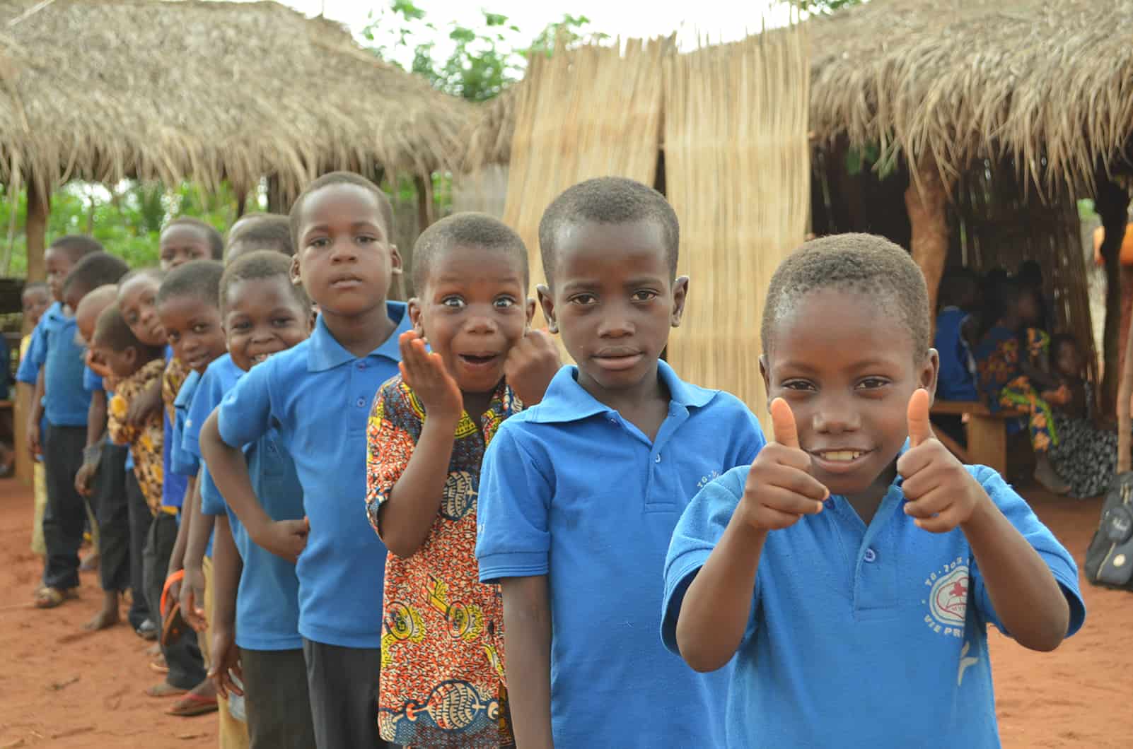 A line of kids in togo with one making a funny face