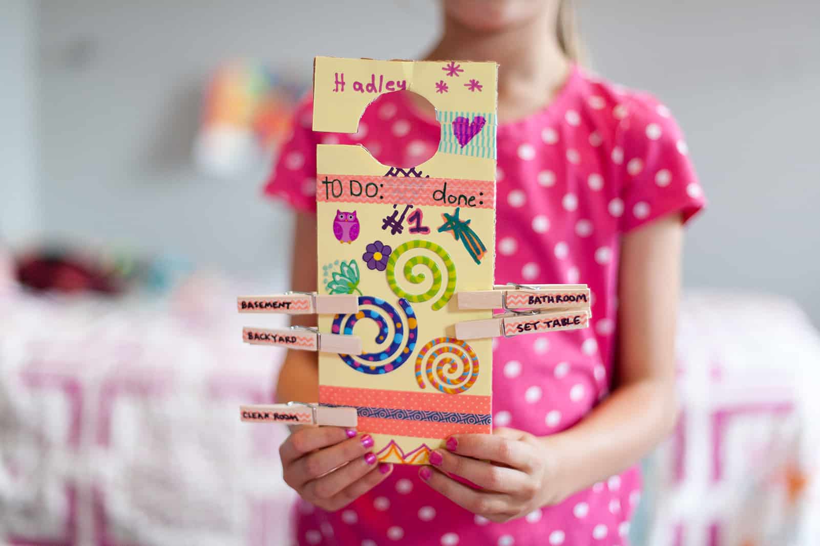 Girl holding door hanger chore chart