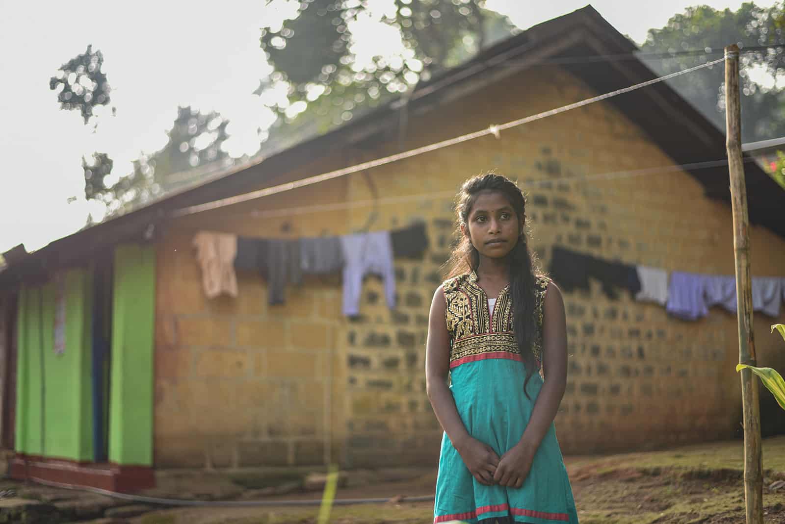 Girl standing in front of a house and clothesline