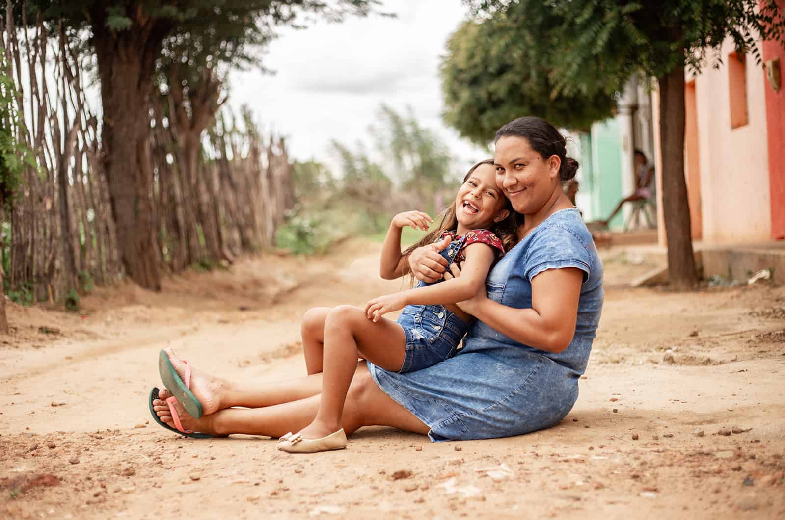 Happy mother and daughter sitting on the ground