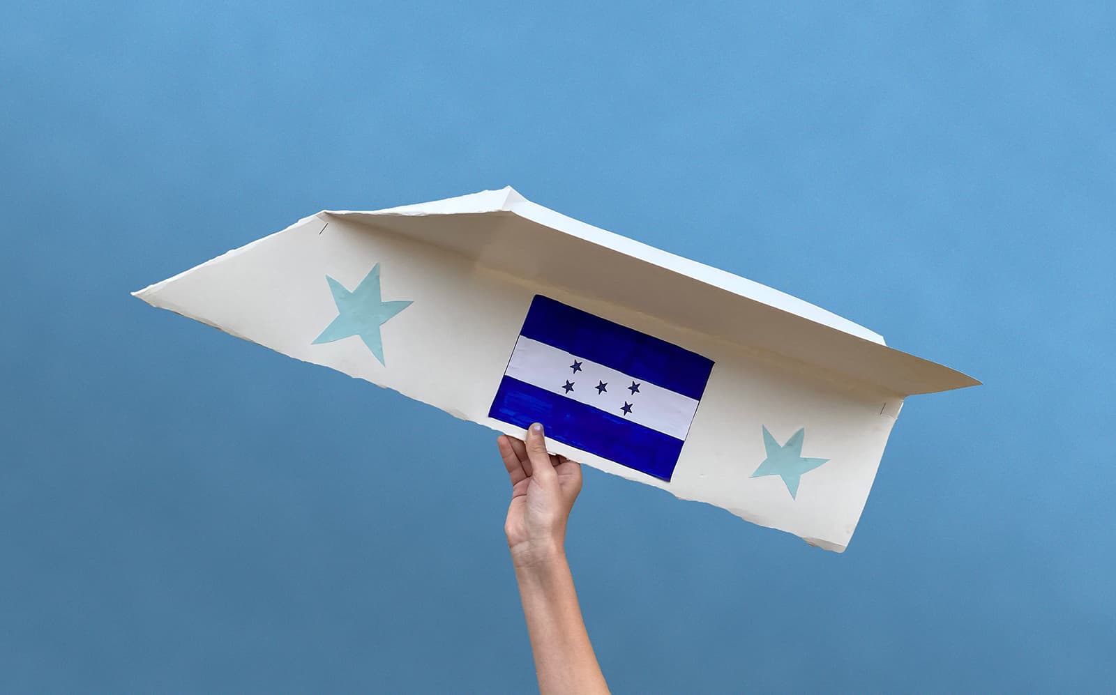 Fun family activities at home: Large paper airplane decorated with Honduran flag