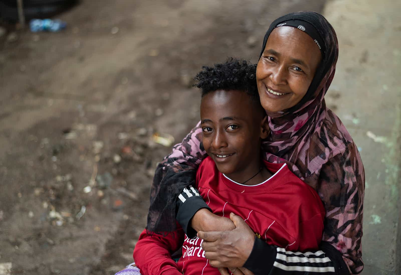 Mother hugging son on a street