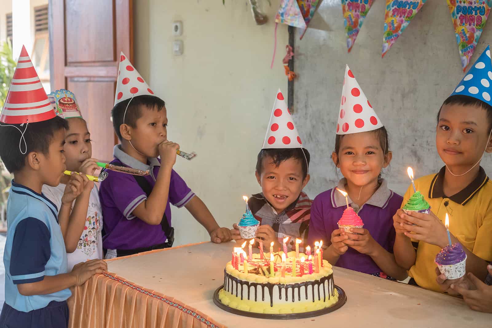 Six boys around the a birthday cake