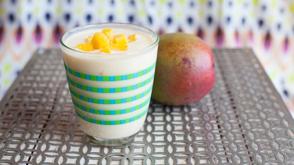 Sri Lankan Mango Lassi drink on a table with a mango