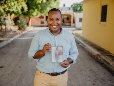 Tony Beltran holding a picture of himself when he was a child