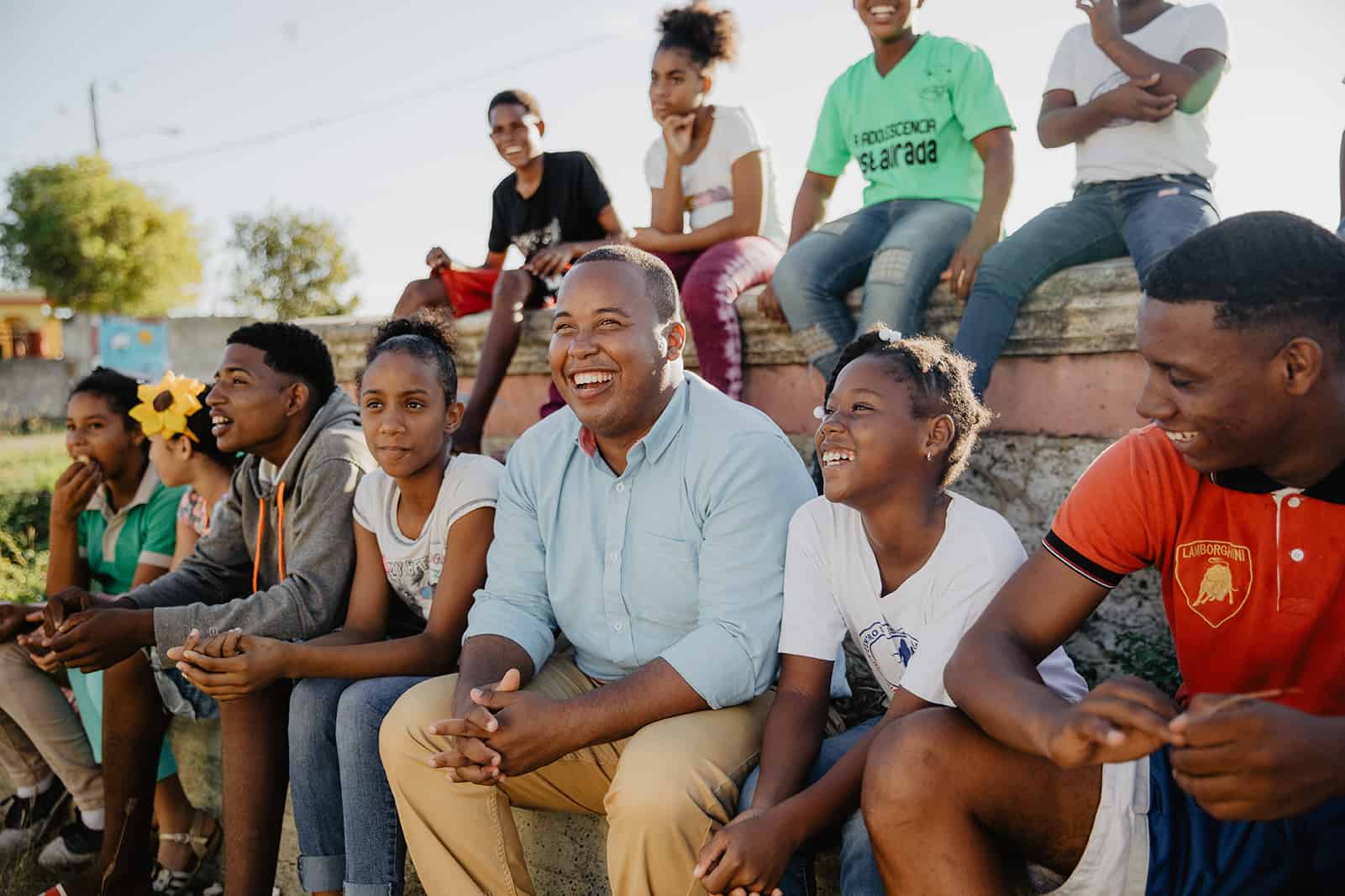 Tony Beltran sitting with kids on bleachers