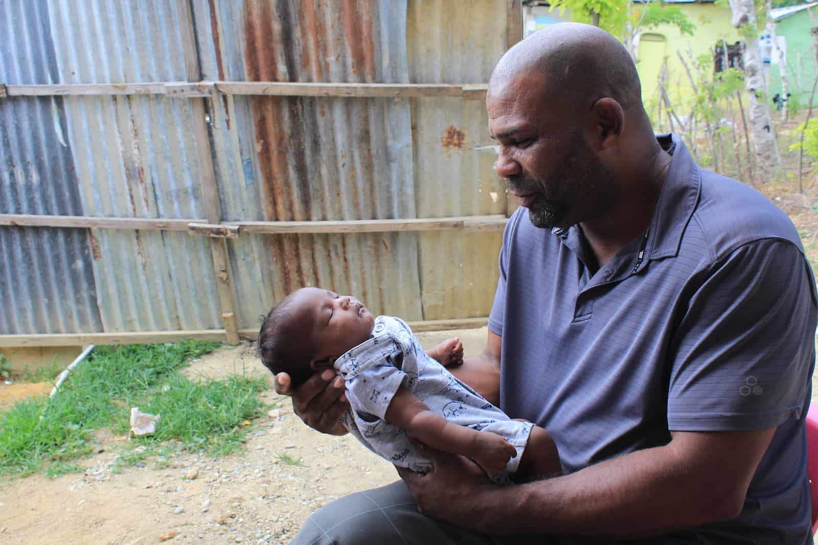 A man holds a newborn baby