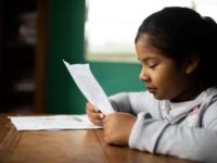 A girl reads a letter.