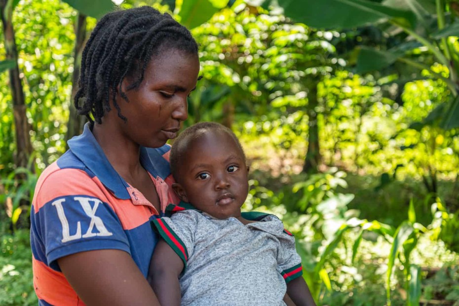 A woman holds a baby in her lap