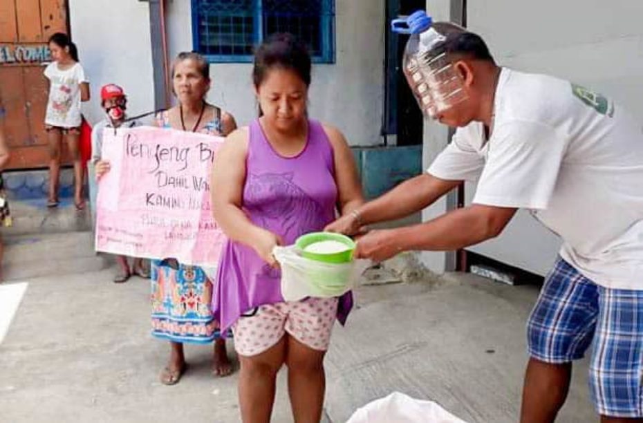 A man wearing a bottle for a face mask hands out food.