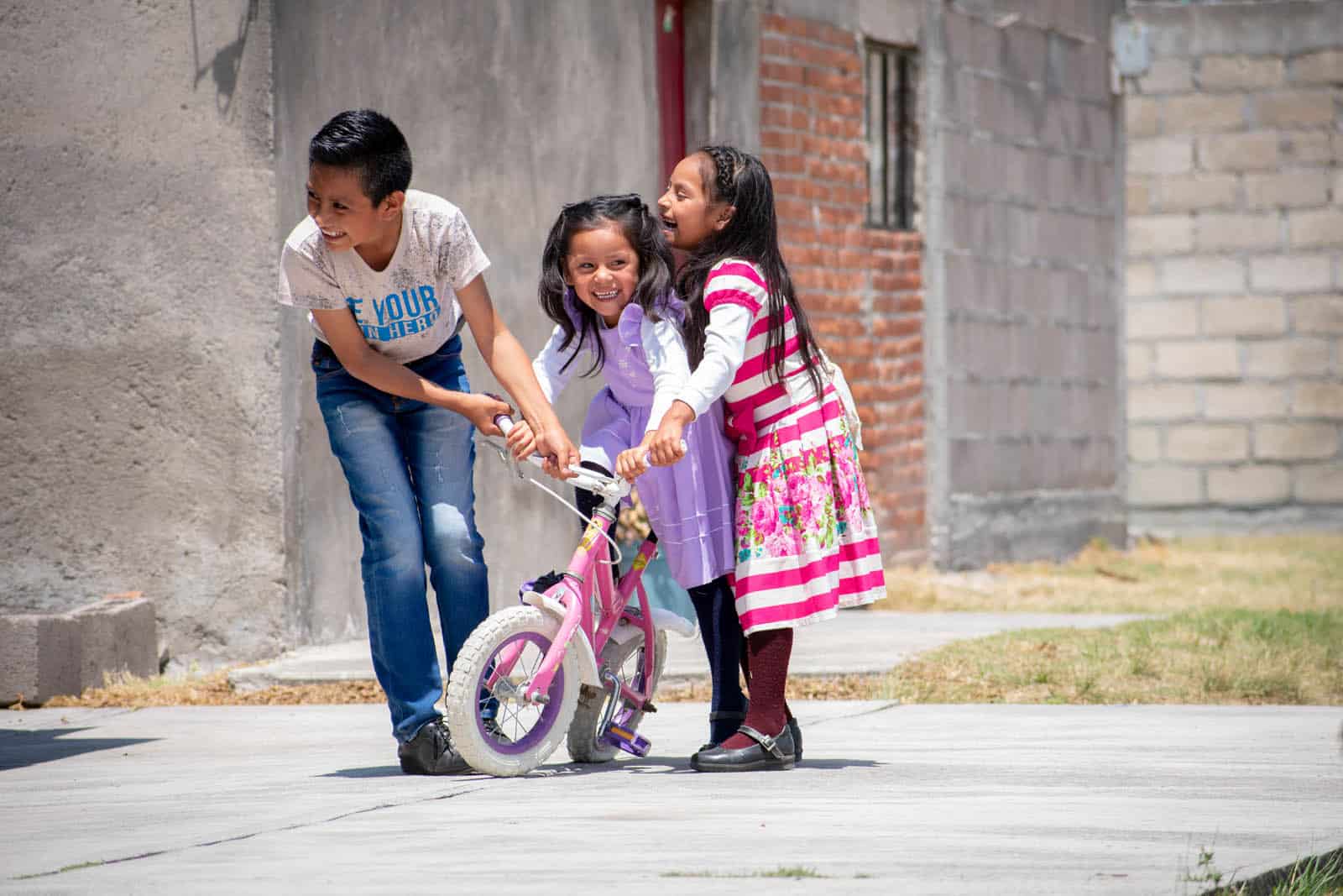 Yael playing on a concrete slab with his sisters