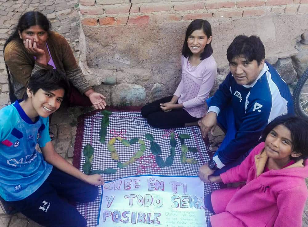 A family sits around a handmade sign
