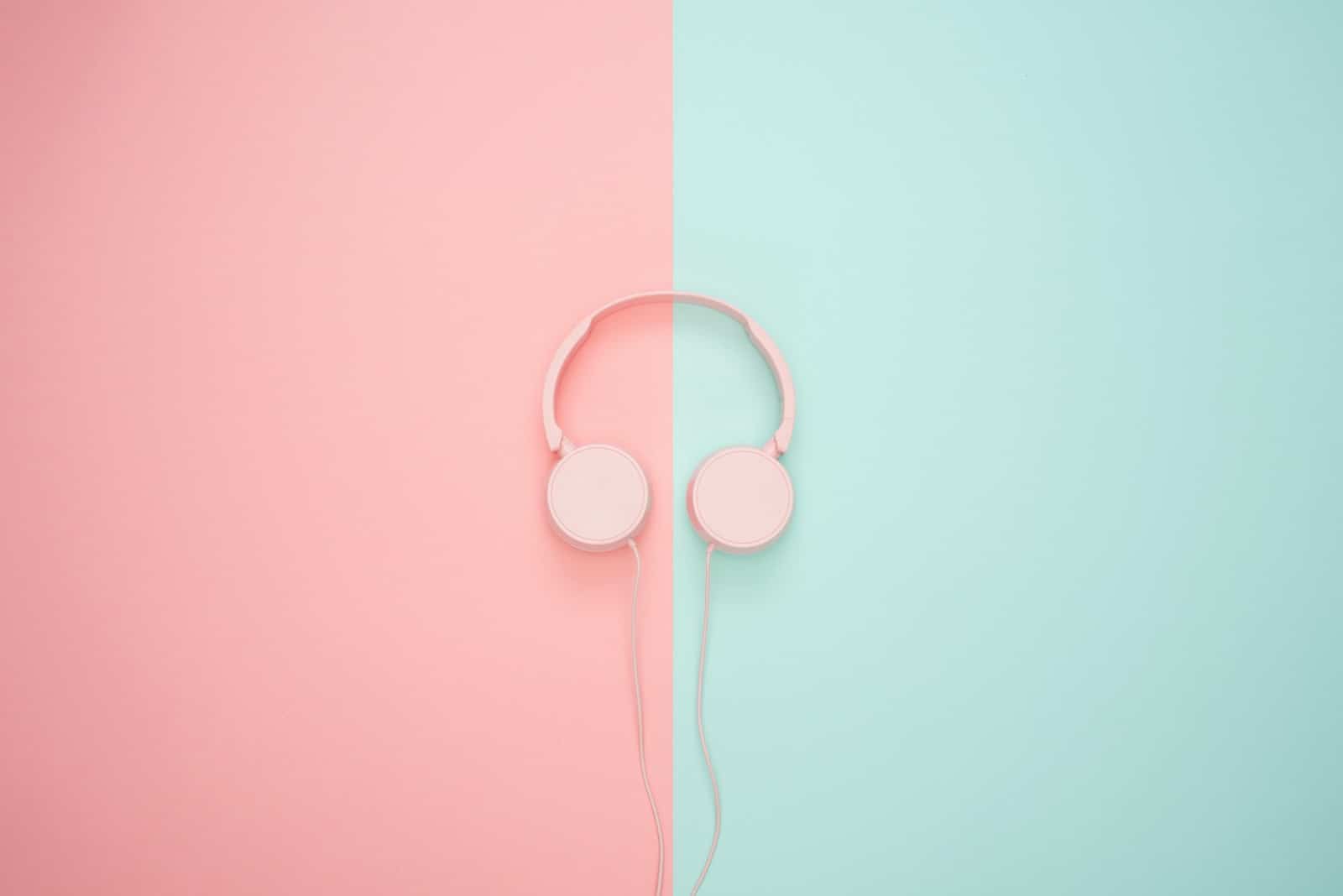 Pink headphones on a pink and green background