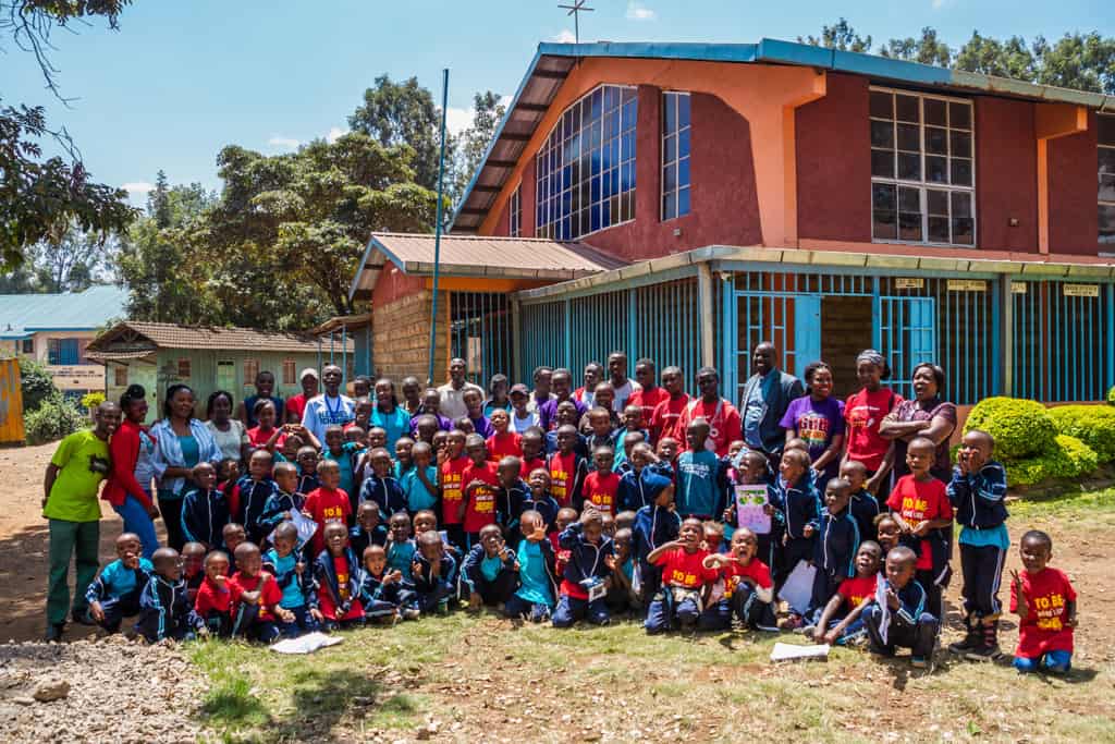 Children and Staff outside a Compassion child development center.