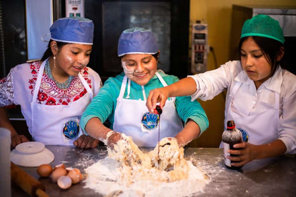 three young ladies mixing dough