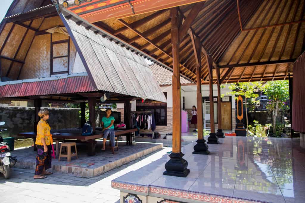 Woman doing a regular visit in one of the homestays and is talking with the owner. She is wearing a yellow shirt.