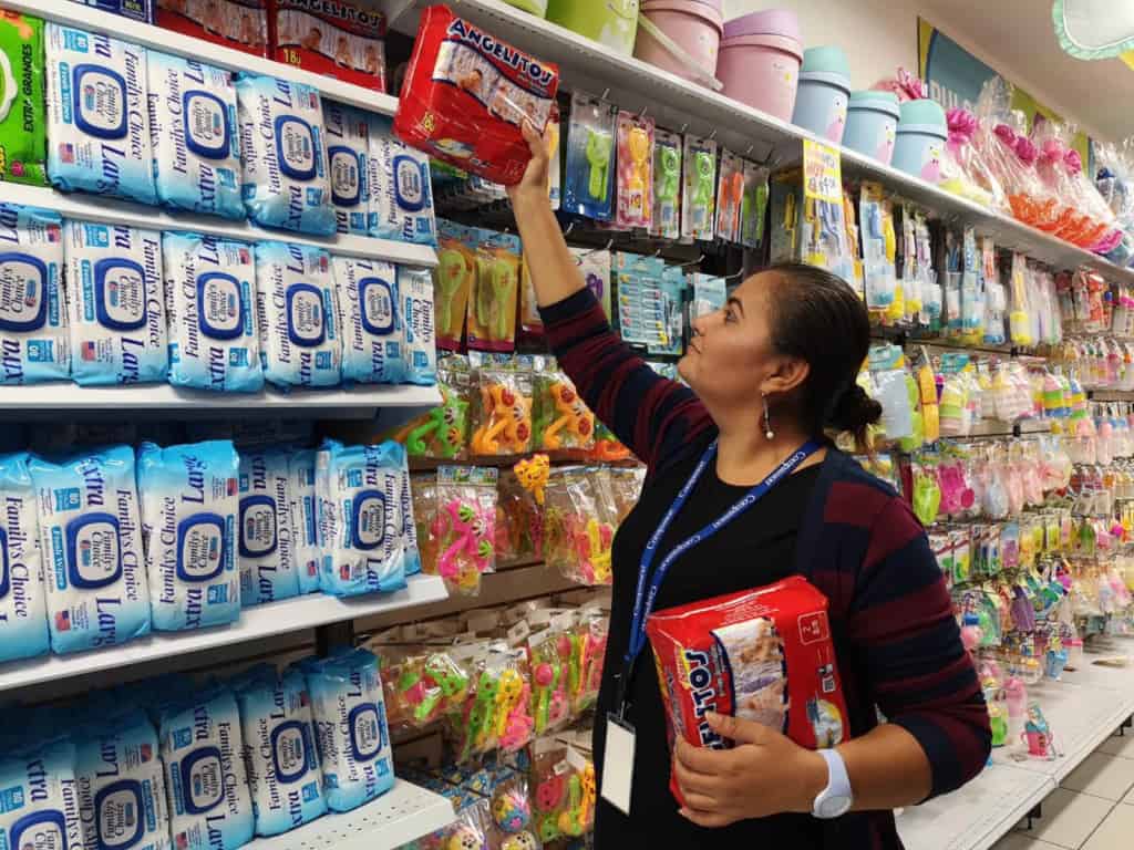 Carmen Mejía is buying diapers for a newborn survival baby affected by heavy rains from Hurricane Michael.