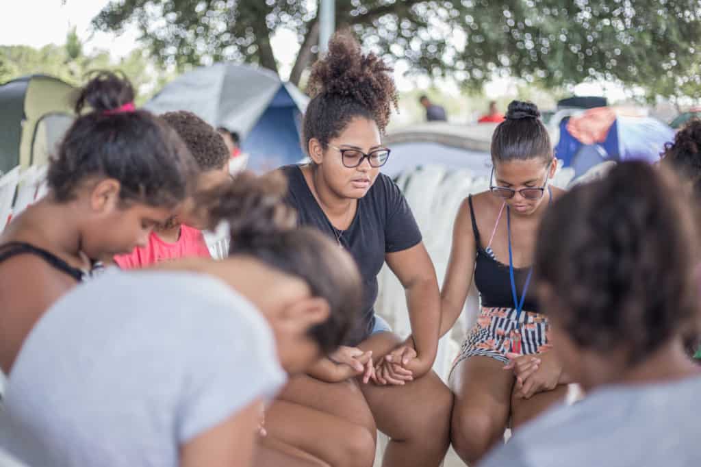 Jenyffer prays with other beneficiaries and friends from the church.