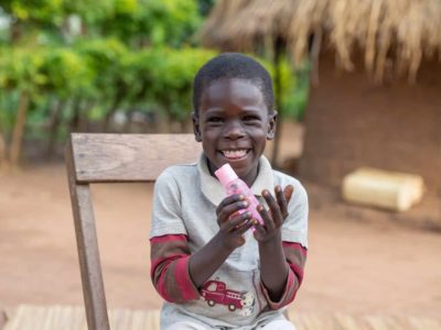 young boy with a huge smile sitting