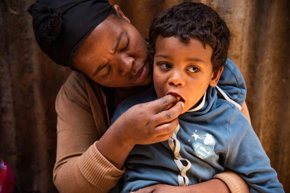 A mother in Ethiopia feeds her 4-year-old son