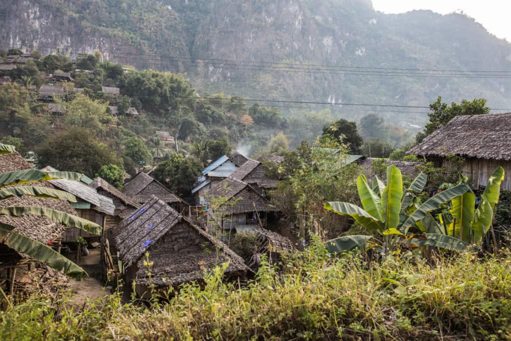 horizontal, wide angle picture of refugee houses in Mae La refugee camp from the fence at the road.