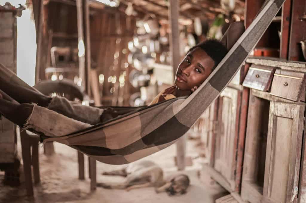 A boy lays in the hammock where he sleeps every night. The house where he and his family live has just one bedroom, so João and his brother sleep in the living room.