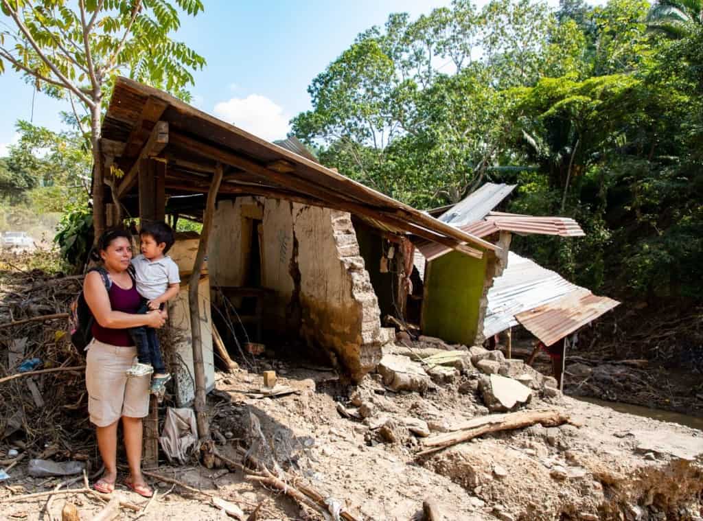 Anderson and his mother Keylin stand in front of their home in Honduras in after it was damaged by Hurricane Eta.