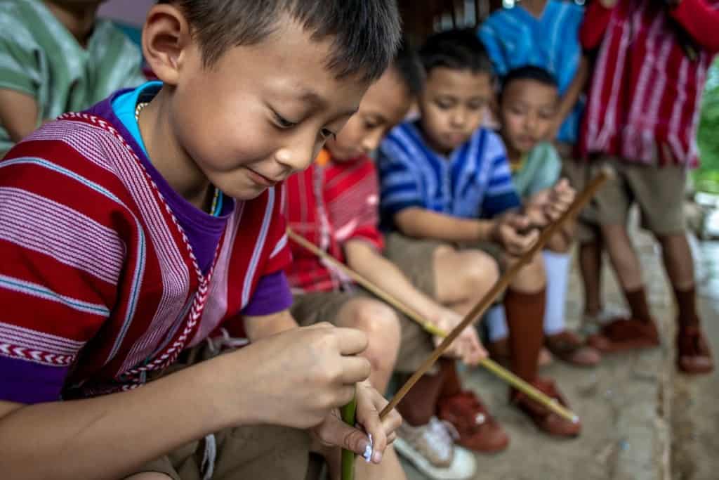 Children in Thailand load their bamboo shoots with wet paper, getting ready to play boe-thor.
