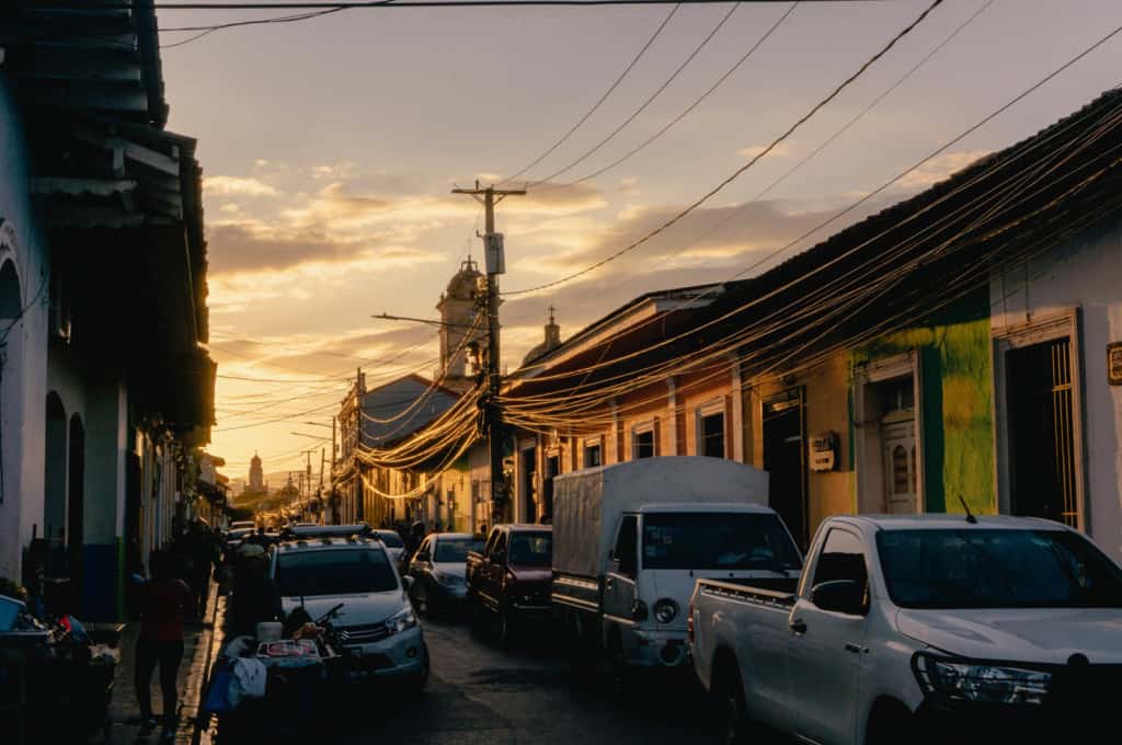 Car-lined street at sunset.