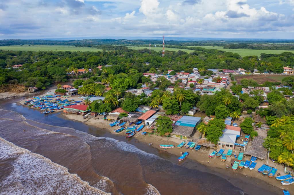 Aerial photograph of the seashore with colorful boats on the shore.