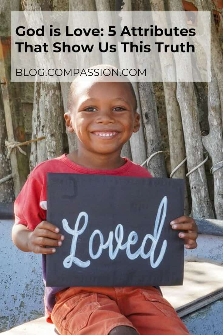 Boy holding a chalkboard with the word loved written on it