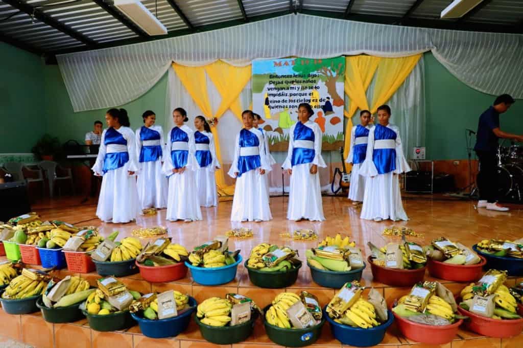 Girls aged 13-15 years old are wearing white and blue worship dancewear. They are performing on the church stage.