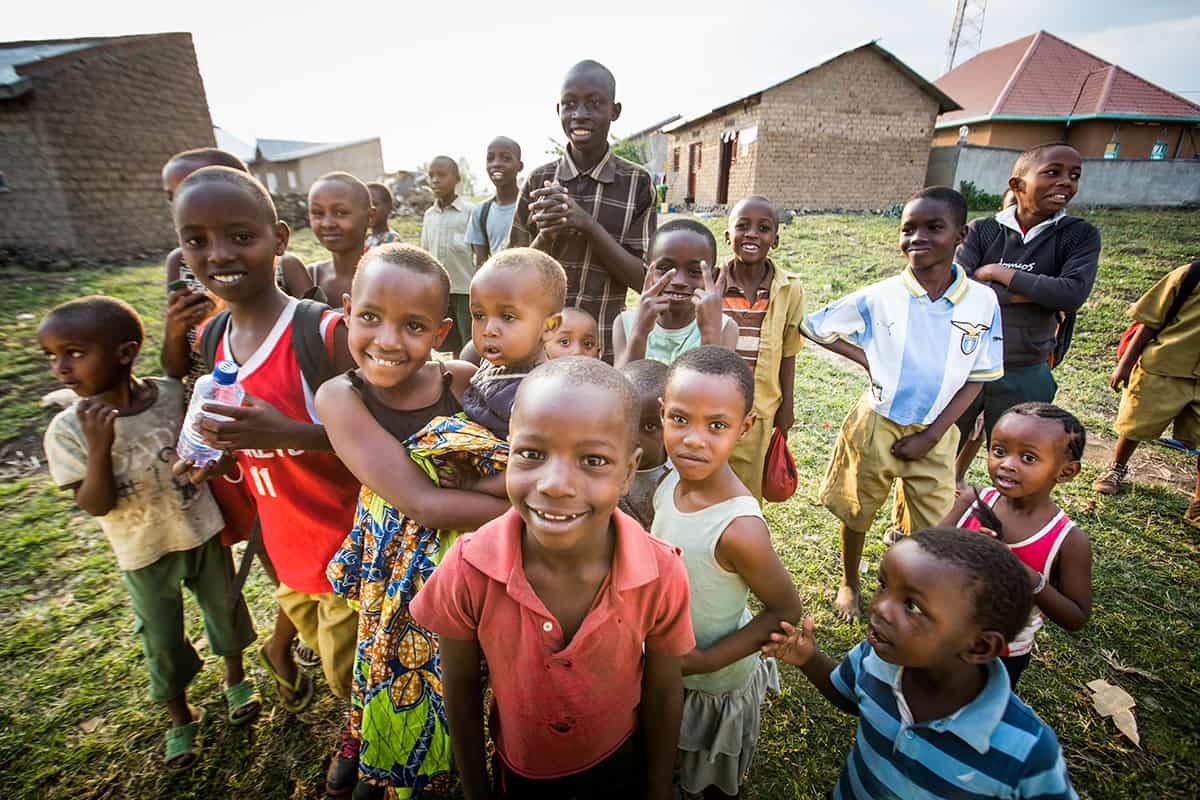 A group of children and youth smile outside in Rwanda