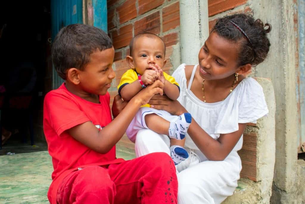 Baby Deinner and his older brother and sister are outside their home in Colombia