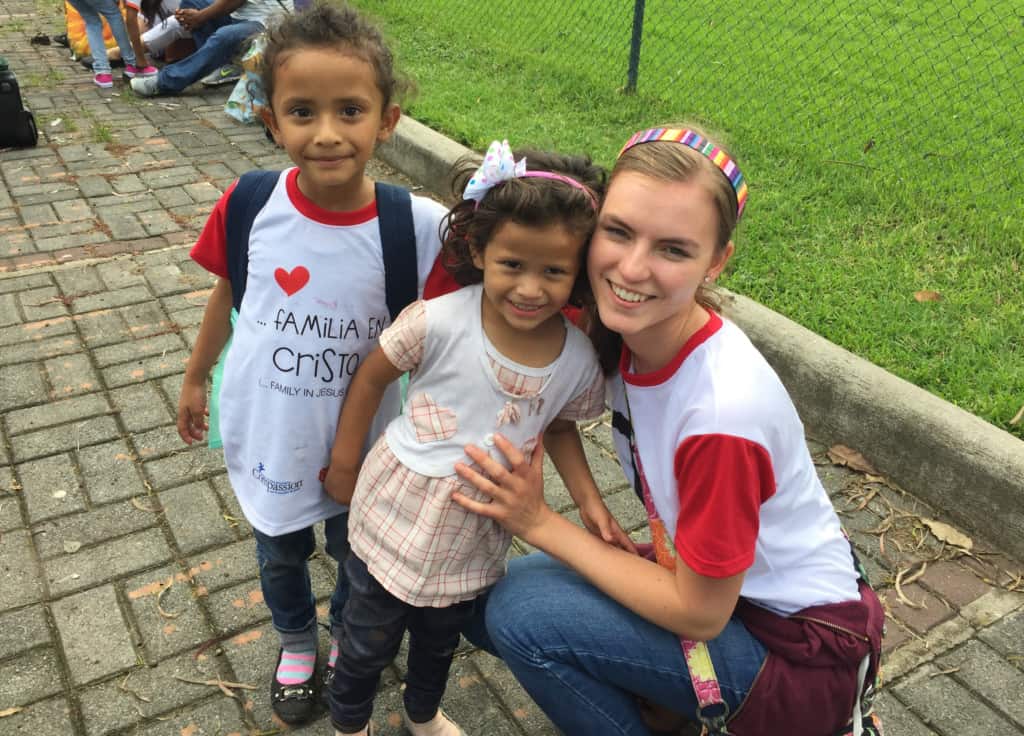 A woman and two children in Guatemala smile at the camera.