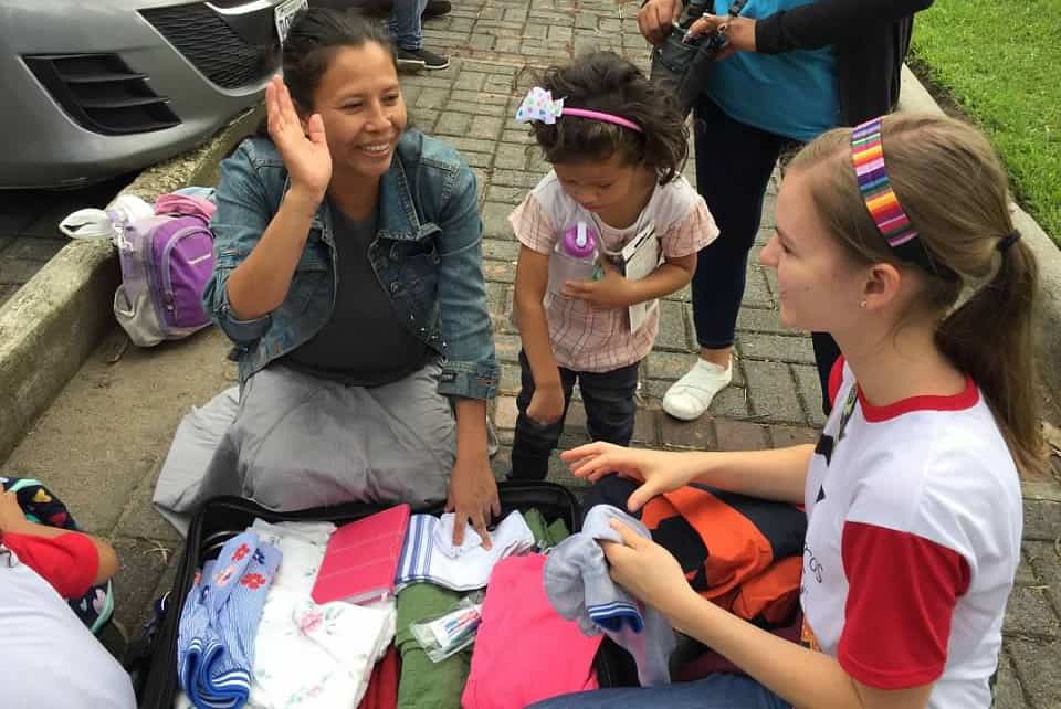 A mother and her daughter in Guatemala open a suitcase of gifts given to them by the girl's sponsor.